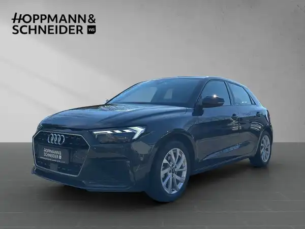 Das Bild zeigt einen schwarzen AUDI A1 SPORTBACK aus der Frontansicht. Das Händlersymbol von HOPPMANN & SCHNEIDER ist sichtbar.