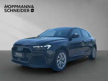 Das Bild zeigt einen schwarzen AUDI A1 SPORTBACK aus der Frontansicht. Das Händlersymbol von HOPPMANN & SCHNEIDER ist sichtbar.