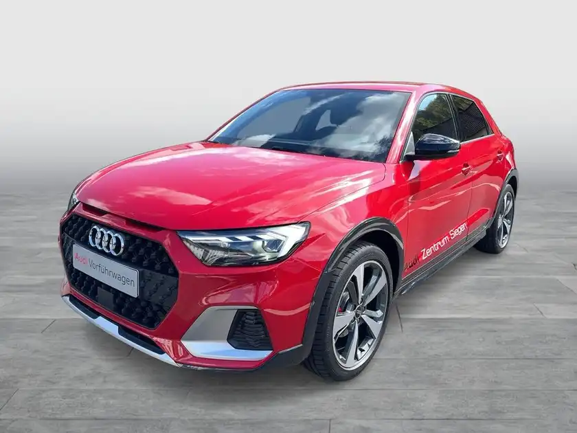 Das Bild zeigt einen roten AUDI A1 aus der Seitenansicht. Es enthält markante Texteinblendungen.