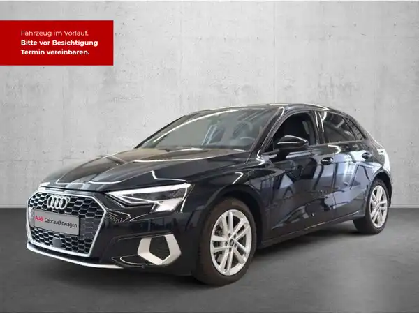 Das Bild zeigt einen schwarzen AUDI A3 SPORTBACK, aufgenommen von der Seite. Es gibt ein Händlerlogo und markante Texteinblendungen.