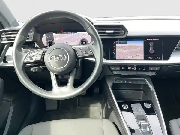 Das Bild zeigt das Innenmotiv des Audi A3 Sportback, mit einem Armaturenbrett und einem Display, das Fahrassistenzinformationen anzeigt.