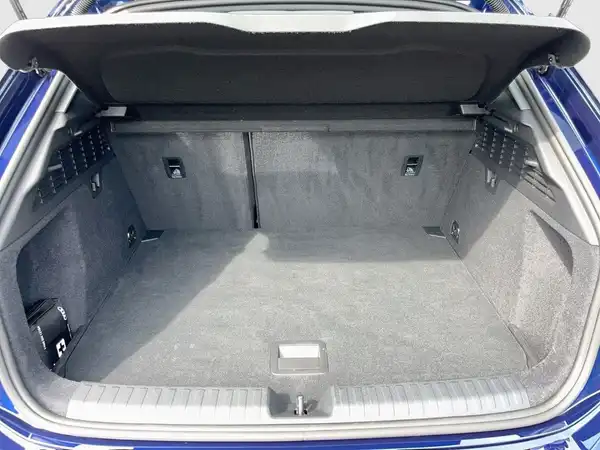 Das Bild zeigt den Innenraum eines Audi A3 Sportback, aufgenommen aus der Sicht des Rücksitzes. Die Farbe des Fahrzeugs ist blau und das Interieur ist grau.