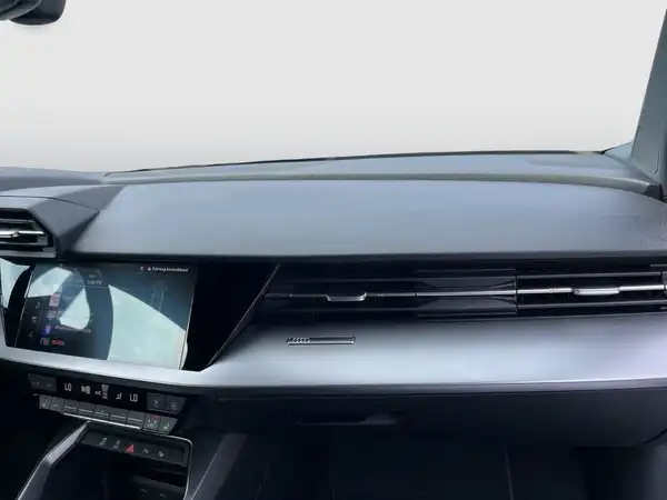 Das Bild zeigt den Innenraum eines Audi A3 Sportback mit schwarzen Sitzen und Armaturen.
