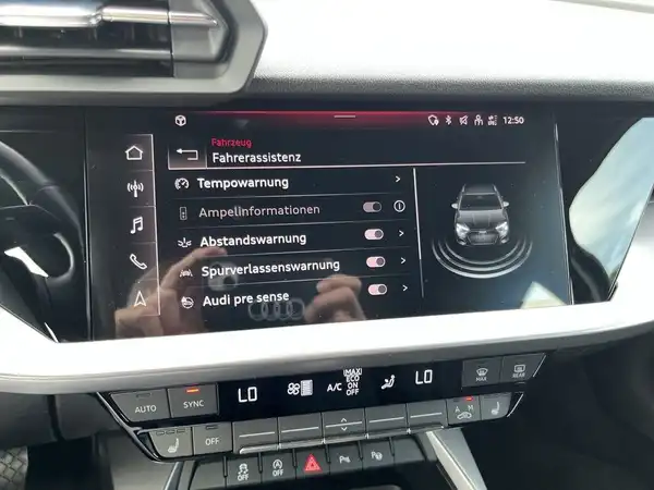 Das Bild zeigt das Innere eines AUDI A3 Sportback, insbesondere die Türverkleidung in schwarzem Design mit Bedienelementen, das Fahrzeug hat eine blaue Außenfarbe.