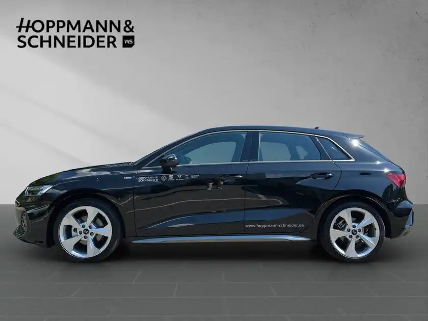 Das Bild zeigt einen schwarzen AUDI A3 SPORTBACK von der Seite. Es ist ein Händlerlogo eingeblendet, und es sind markante Texteinblendungen vorhanden.