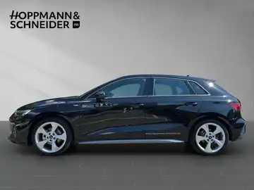 Das Bild zeigt einen schwarzen AUDI A3 SPORTBACK von der Seite. Es ist ein Händlerlogo eingeblendet, und es sind markante Texteinblendungen vorhanden.