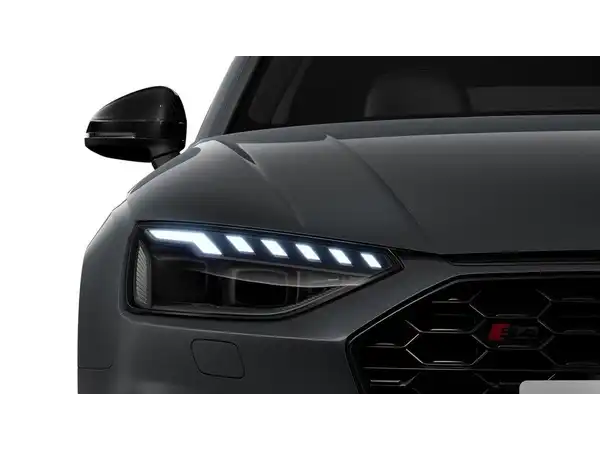 Das Bild zeigt die Frontansicht eines grauen AUDI S4 AVANT mit Fokus auf die Scheinwerfer und den Kühlergrill.