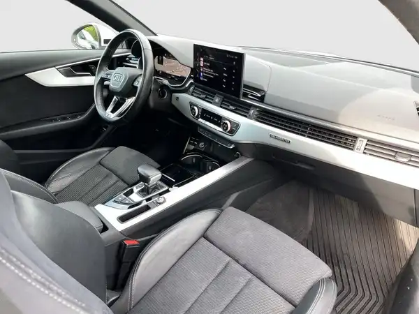 Das Bild zeigt das Innere eines AUDI A4 AVANT mit einer Kombination aus schwarzem und grauem Interieur, das aus Stoff und Leder besteht.