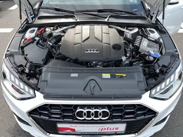 Das Bild zeigt den Motorraum eines weißen AUDI A4 AVANT. Das Händlerinformationen sind sichtbar.