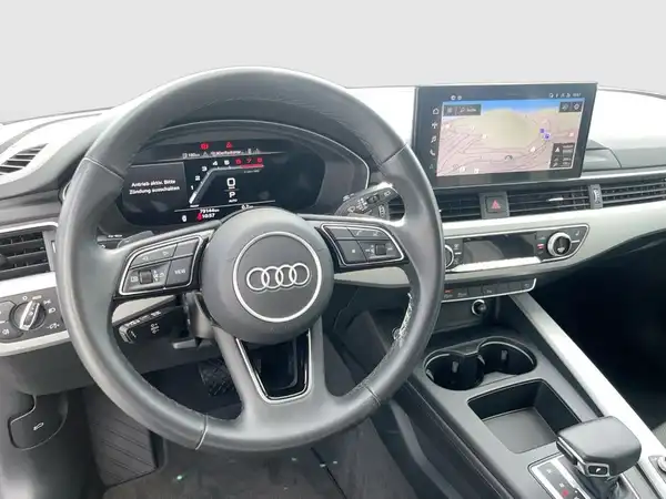 Das Bild zeigt das Innere eines AUDI A4 AVANT, aufgenommen von der Fahrerseite. Die Innenfarbe ist schwarz und es gibt markante Texteinblendungen auf dem Bildschirm.
