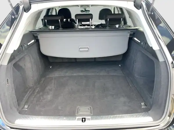 Das Bild zeigt den Innenraum des Kofferraums eines AUDI A4 AVANT in Schwarz.
