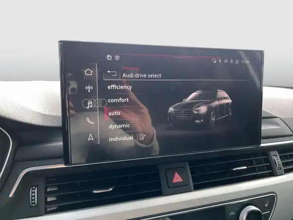 Das Bild zeigt das Innenleben eines Audi A4 Avant mit einem Bildschirm, auf dem verschiedene Fahrmodi angezeigt werden.
