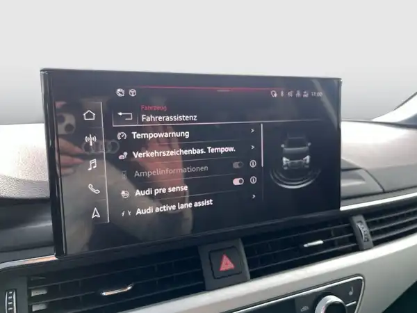 Das Bild zeigt den Innenraum eines Audi A4 Avant mit dem Infotainment-Bildschirm, auf dem verschiedene Funktionen der Fahrassistenz angezeigt werden.