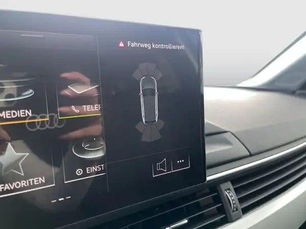 Das Bild zeigt das Innenleben eines AUDI A4 AVANT mit einem Display, auf dem eine Nachricht angezeigt wird. Das Interieur ist schwarz.