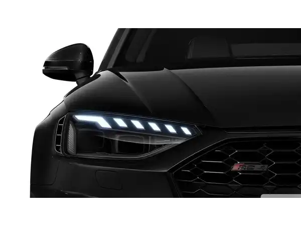 Das Bild zeigt die Frontansicht eines schwarzen AUDI RS4 AVANT mit beleuchteten Scheinwerfern.