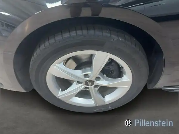 Das Bild zeigt die Seite eines AUDI A4 AVANT mit einem Fokus auf dem Rad und der Felge. Das Fahrzeug ist schwarz.