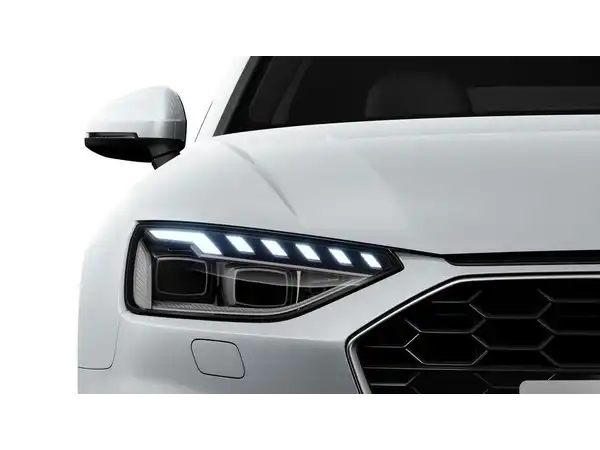 Das Bild zeigt die Frontansicht eines weißen Audi A4 Avant, insbesondere die Scheinwerfer und den Kühlergrill.
