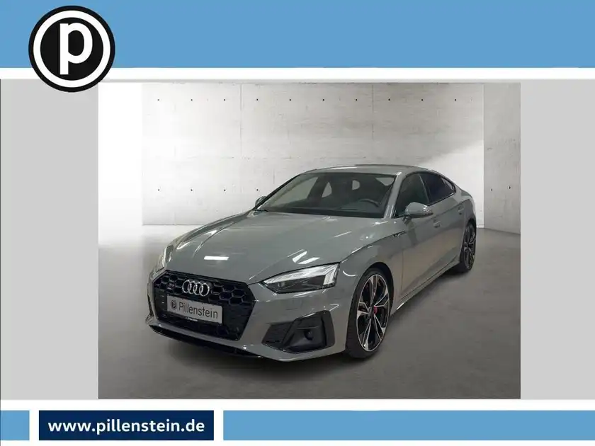 Das Bild zeigt einen grauen Audi S5, von der Seite aufgenommen. Das Händlersymbol ist eingeblendet.