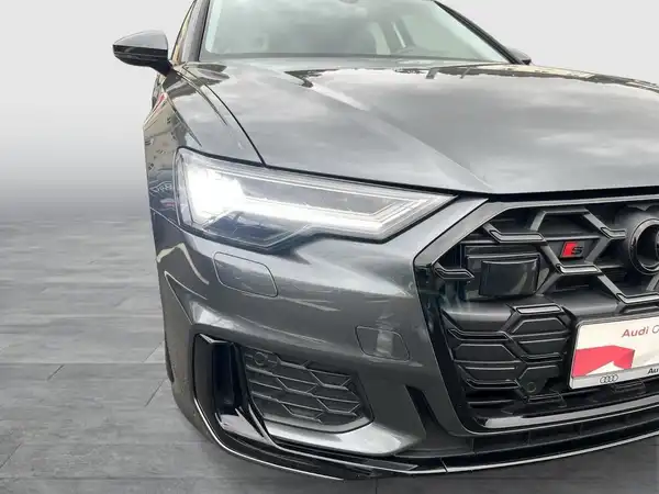 Das Bild zeigt einen Audi S6 Avant aus der Frontalansicht in schwarz mit einem Händlerlogo im Bild.