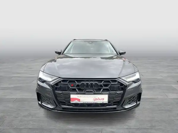 Das Bild zeigt einen schwarzen Audi S6 Avant aus der Frontalansicht. Im Bild ist das Händlerlogo zu sehen und es gibt markante Texteinblendungen.