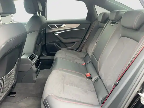 Das Bild zeigt das Innere eines AUDI A6, aufgenommen von hinten. Die Sitze sind schwarz.