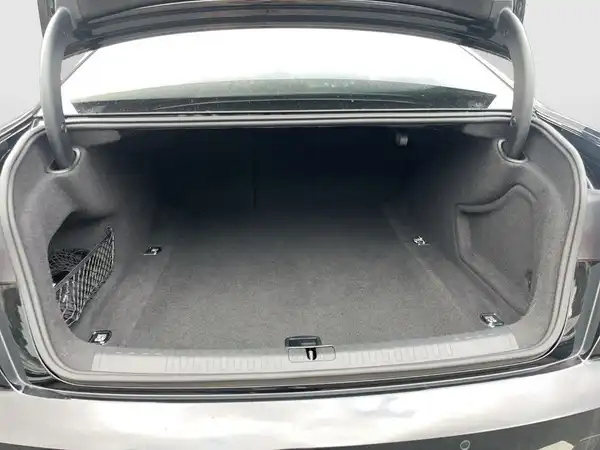 Das Bild zeigt den Kofferraum eines AUDI A6 in Schwarz von hinten. Der Kofferraum hat ein graues Interieur.