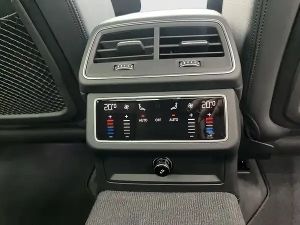 Das Bild zeigt eine Innenaufnahme des Fahrzeugs, insbesondere die Bedienelemente der Klimaanlage im dunkelgrauen Interieur.