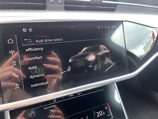 Das Bild zeigt das Innenleben eines AUDI A6 mit einem Bildschirm, der verschiedene Fahrmodi anzeigt. Die Farbe des Interieurs ist schwarz.