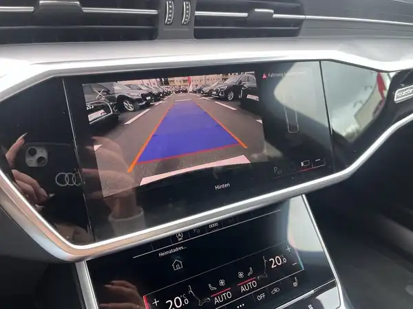 Das Bild zeigt das Navigations- und Rückfahrmonitor des Audi A6 mit einem Blick auf die Umgebung hinter dem Fahrzeug.