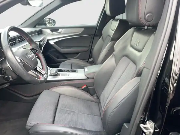 Das Bild zeigt den Innenraum eines AUDI A6 mit schwarzen Sitzen und grauen Akzenten.
