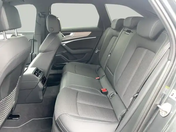 Dieses Bild zeigt den Innenraum eines Audi A6 Avant, mit einer schwarzen Rückbank und modernen Designelementen.