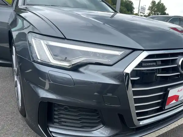 Das Bild zeigt einen grauen AUDI A6 AVANT aus der Frontalansicht, mit gut sichtbarem Händlerlogo und zusätzlichen Texteinblendungen.
