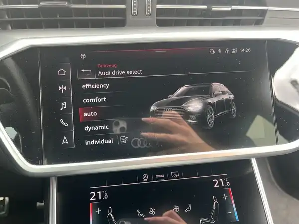 Das Bild zeigt das Innere eines AUDI A6 AVANT mit einem Bildschirm, der die verschiedenen Fahrmodus-Optionen anzeigt.