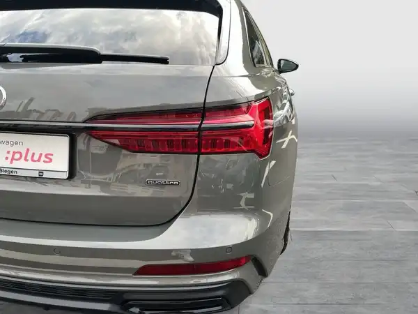 Das Bild zeigt die Rückansicht eines grauen Fahrzeugs, vermutlich ein AUDI A6 AVANT. Es enthält ein Händelrlogo und markante Texteinblendungen.