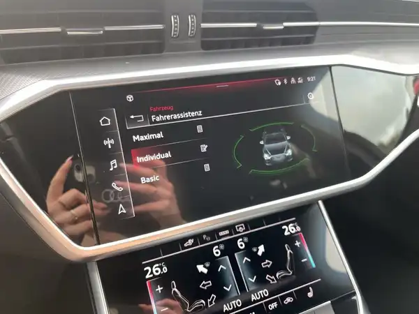 Das Bild zeigt das Innenraumdisplay eines AUDI A6 AVANT mit einem Schwarz-Interieur und verschiedenen Einstellungen für den Fahrassistenten.