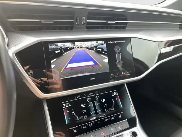 Das Bild zeigt das Innenleben des Fahrzeugs, speziell das Navigations- und Rückfahrkamera-Display, mit einer schwarzen Innenausstattung.