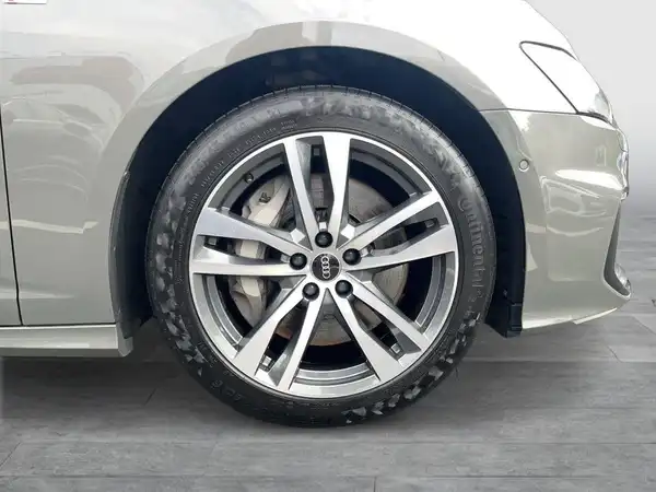 Das Bild zeigt einen seitlichen Blick auf das Fahrzeug, speziell auf das Rad und den Kotflügel eines silbernen AUDI A6 AVANT.