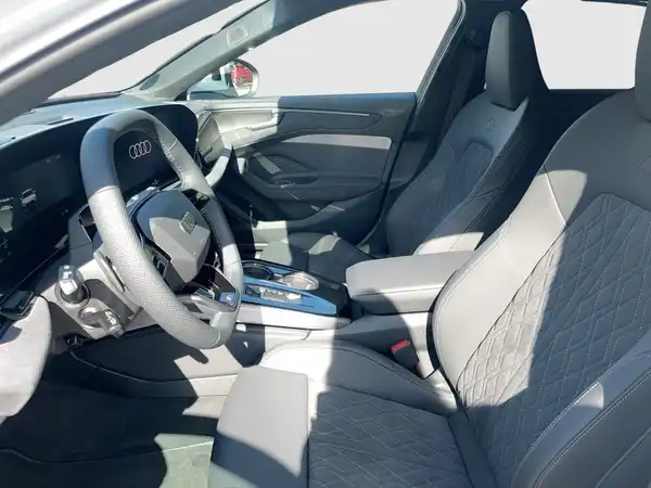 Das Bild zeigt das Innere eines Audi A6 Avant in grauer Farbe. Es sind die Sitze und das Armaturenbrett sichtbar.