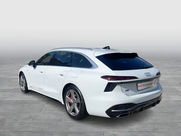 Das Bild zeigt einen weißen Audi A6 Avant von hinten, mit einem Händlerlogo im Bild.