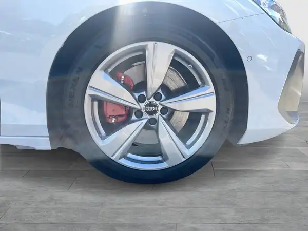 Das Foto zeigt die Seite eines AUDI A6 AVANT in weiß, mit einem Fokus auf einem Rad und dem Reifen.