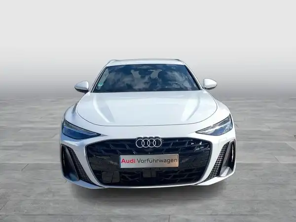 Das Bild zeigt einen weißen Audi A6 Avant von vorne. Im Bild ist ein Händlerlogo mit dem Text 'Audi Vorführwagen' eingeblendet.