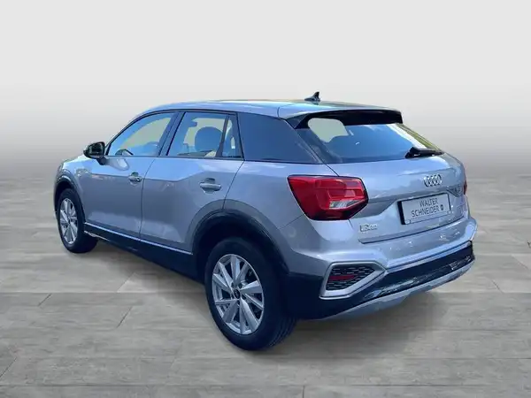 Das Bild zeigt einen silbernen AUDI Q2 von hinten. Es handelt sich um ein Fahrzeugbild.