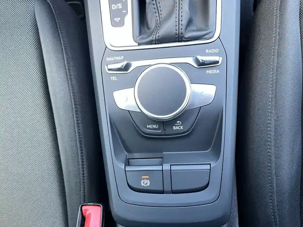 Das Bild zeigt das Interieur eines Fahrzeugs mit einem schwarzen Armaturenbrett und Bedienelementen.