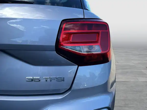 Das Bild zeigt die Rückansicht eines silbernen Audi Q2, das Rücklicht und das Modellkennzeichen 35 TFSI sind gut sichtbar.