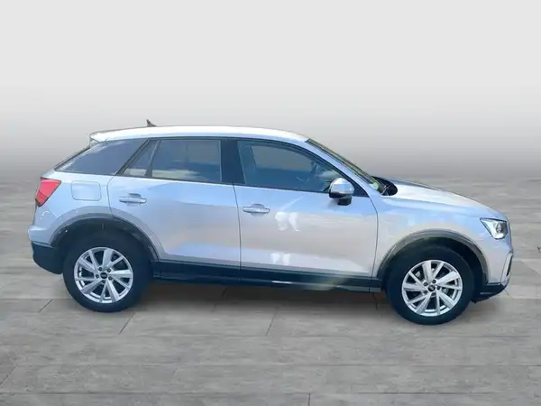 Das Bild zeigt einen silbernen Audi Q2 aus seitlicher Perspektive.