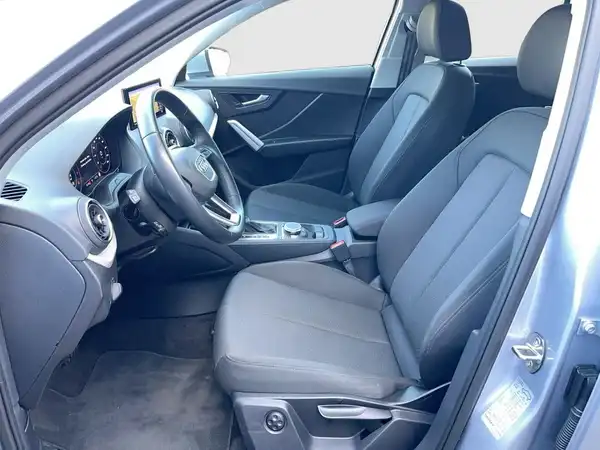 Das Bild zeigt den Innenraum eines Fahrzeugs (Audi Q2) mit schwarzen Sitzen und einem modernen Armaturenbrett.