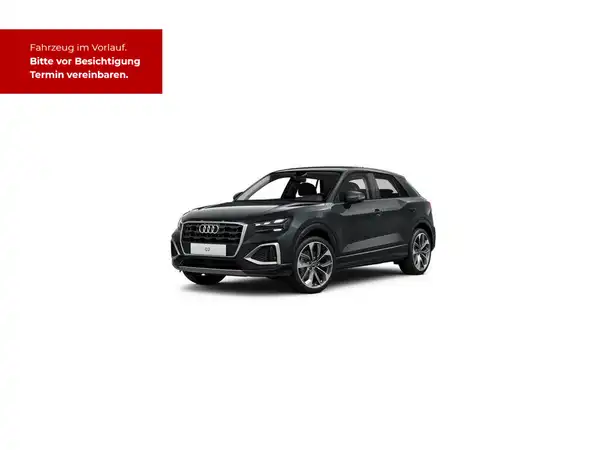 Das Bild zeigt einen schwarzen Audi Q2 aus der Seitenansicht. In der oberen linken Ecke befindet sich eine rote Texteinblendung mit der Aufschrift: 'Fahrzeug im Vorlauf. Bitte vor Besichtigung Termin vereinbaren.'