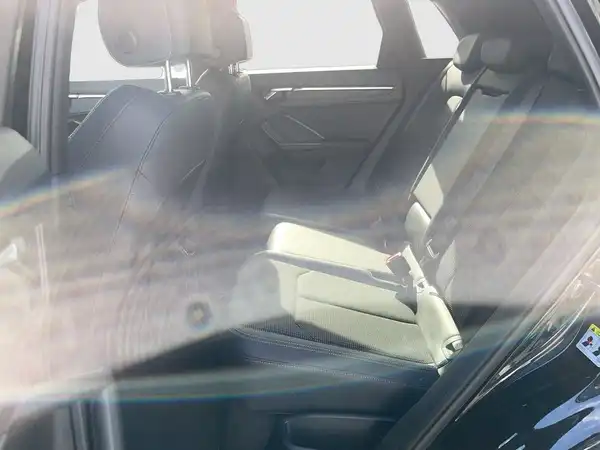 Innenaufnahme des Fahrzeugs, das Beifahrer- und Rücksitzbereich in beiger Farbe zeigt.