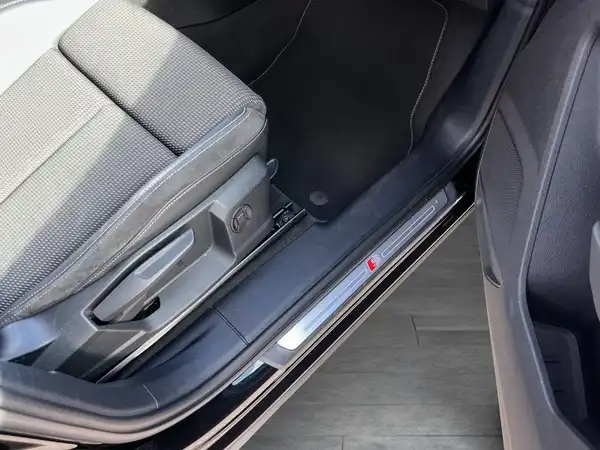 Das Bild zeigt den Innenraum eines AUDI Q3, insbesondere den Sitzbereich mit einem schwarzen Innenraum und grauen Stoffelementen. Es handelt sich um eine Innenaufnahme.