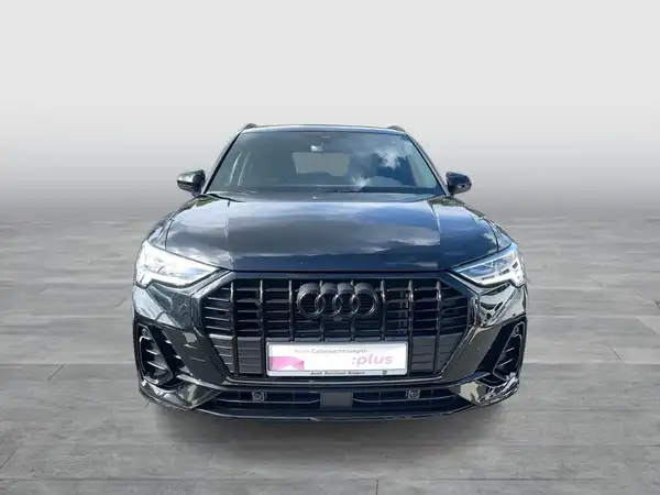 Das Bild zeigt einen schwarzen AUDI Q3 aus der Frontalansicht. Ein Händelrlogo ist sichtbar, aber es gibt keine markanten Texteinblendungen.